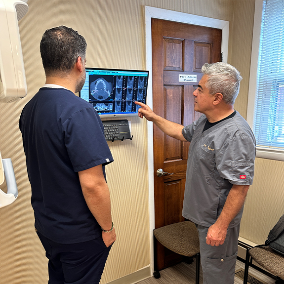 Two periodontists looking at dental x rays in Cranford periodontal office