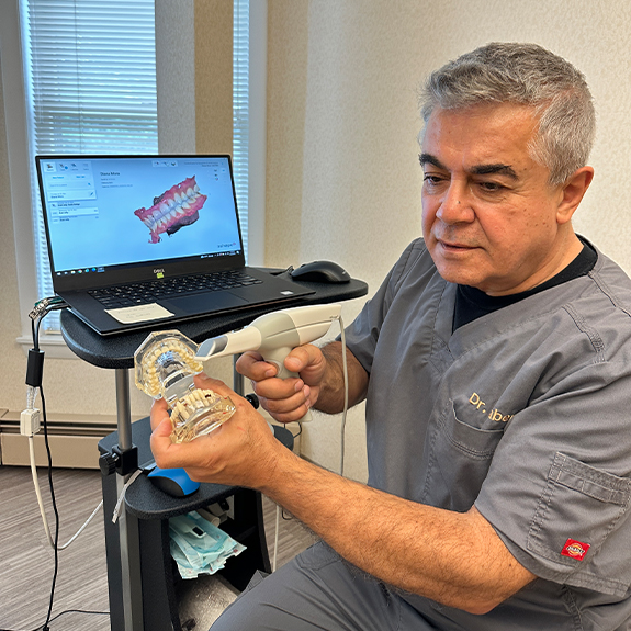 Doctor Saber showing a patient a model of the teeth