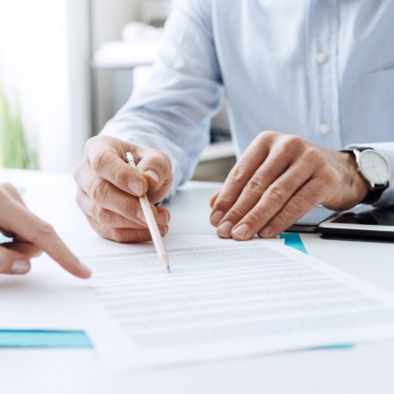 Two people looking carefully at paper form