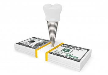 a dental implant on top of a stack of money