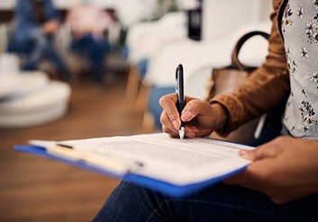 a person signing a form at a dental clinic