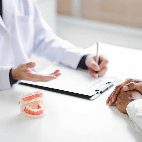 A dentist explaining the implant denture process to a patient