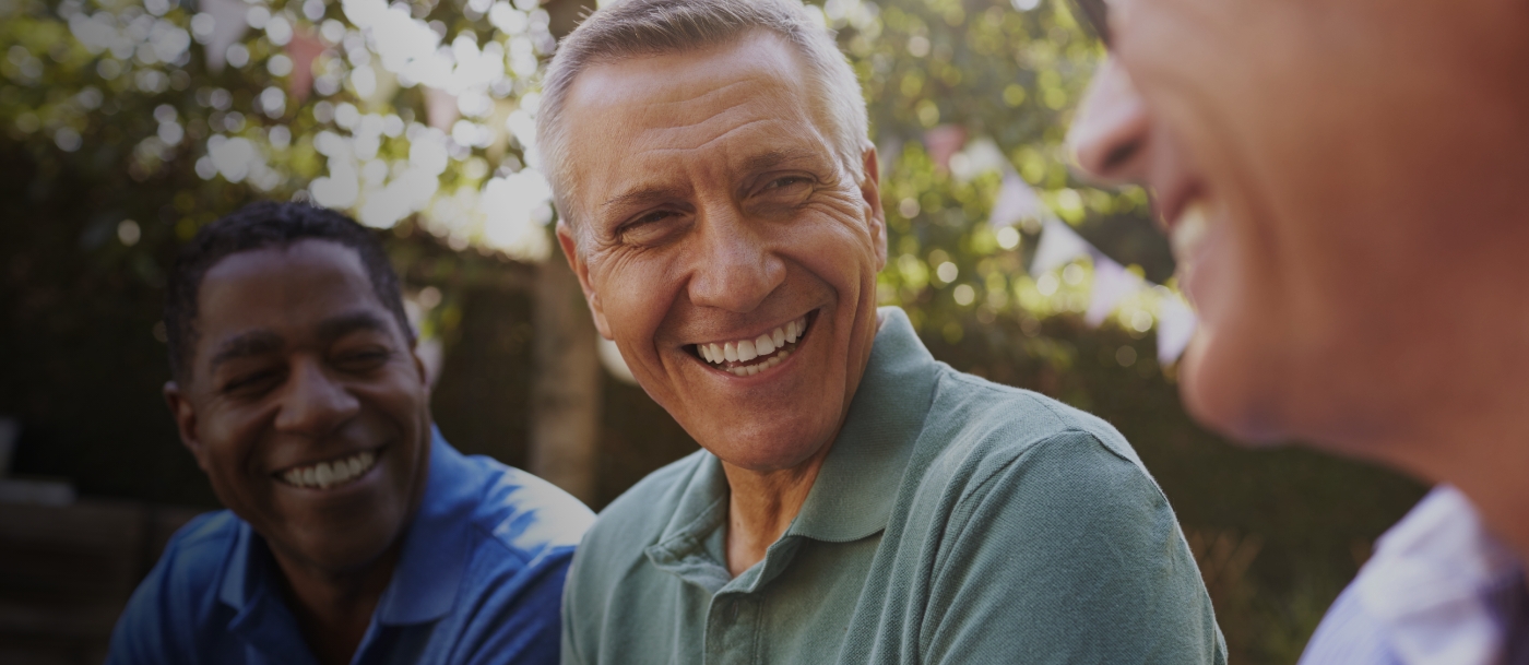 Three men laughing together outdoors after visiting periodontist in Cranford