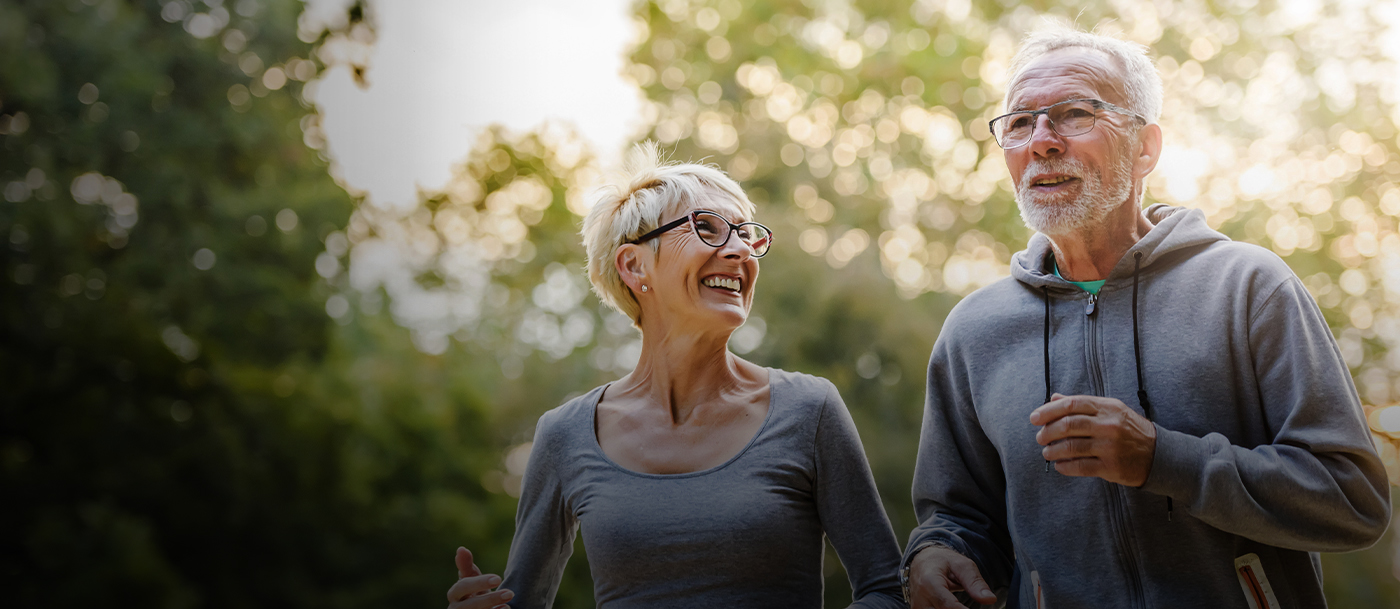 Senior man and woman jogging outdoors