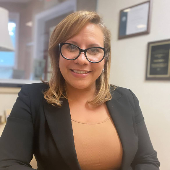 Cranford periodontal office manager Irene smiling at desk