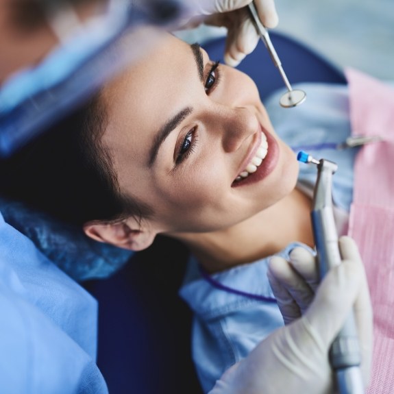 Woman in dental chair smiling before gum disease treatment in Cranford