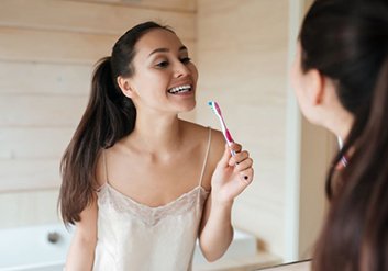 Woman looking at her teeth in bathroom mirror