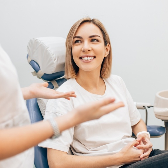 Woman in dental chair listening to her dentist talk