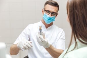 Dentist discussing dental implant with female patient 